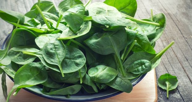 bowl of spinach leaves on cutting board table